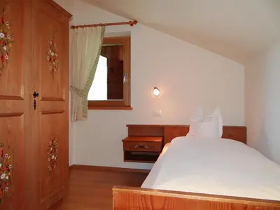 a bedroom with a white bed and a window at Hochwieserhof in Monguelfo