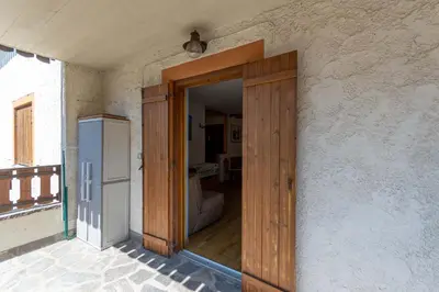 a wooden door in a room with a refrigerator at Casa Riccardo in Soraga