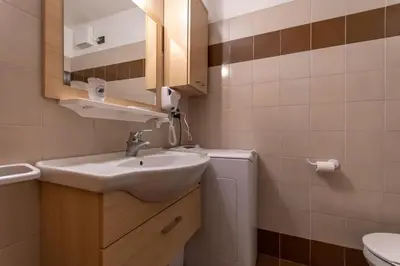 a bathroom with a sink and a toilet at Casa Riccardo in Soraga
