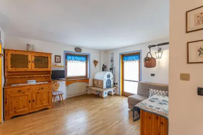 a living room with a couch and a tv at Casa Riccardo in Soraga