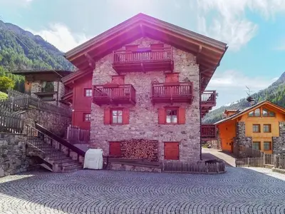 a large building with red doors and balconies on it at Casa Riccardo in Soraga