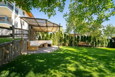 a backyard with a couch and a pergola at Hotel Birkenbrunn in Naz-Sciaves