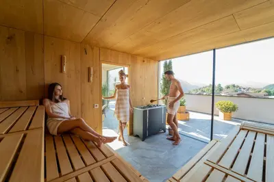 a house with two women sitting on a wooden floor at Hotel Birkenbrunn in Naz-Sciaves