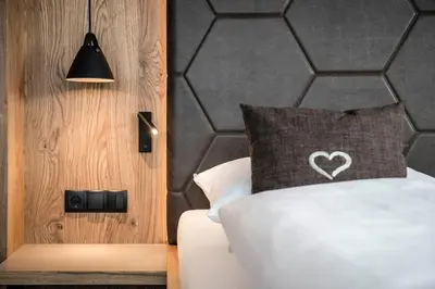 a bedroom with a bed with a heart pillow on it at Hotel Birkenbrunn in Naz-Sciaves
