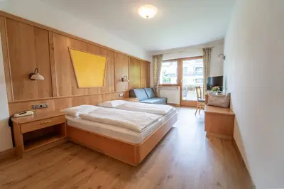 a bedroom with a bed and a desk and a couch at Hotel Birkenbrunn in Naz-Sciaves