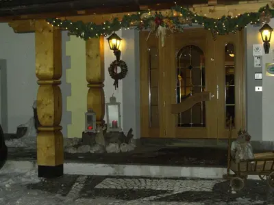a front porch with a christmas wreath and christmas lights at Hotel Vigo in Vigo di Fassa