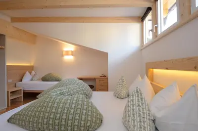 a bedroom with a bed with pillows on it at Mason La Zondra in Vigo di Fassa