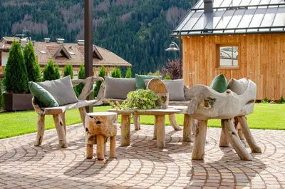 a patio with a wooden table and chairs and a bench at Mason La Zondra in Vigo di Fassa