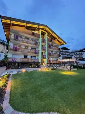 a large building with a lawn in front of it at Mason La Zondra in Vigo di Fassa