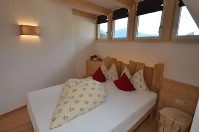 a bedroom with a bed with four pillows on it at Mason La Zondra in Vigo di Fassa