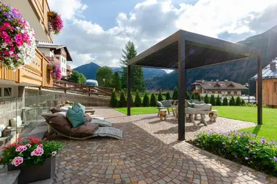 a pavilion with couches and chairs on a patio at Mason La Zondra in Vigo di Fassa
