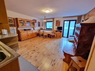 a kitchen with wooden floors and a dining room with a table at Scorpion in Mazzin