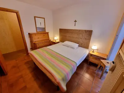 a bedroom with a bed and a cross on the wall at Scorpion in Mazzin