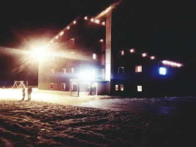 two people standing in front of a building at night at Casa Ciotoli in Falcade
