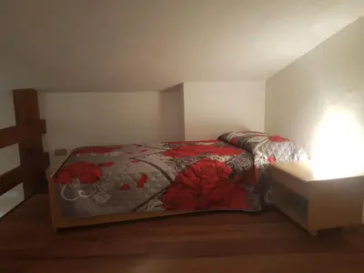 a bedroom with a bed with red flowers on it at Casa Ciotoli in Falcade
