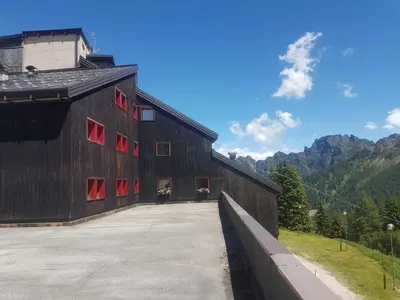 a large wooden barn with red windows on the side at Casa Ciotoli in Falcade