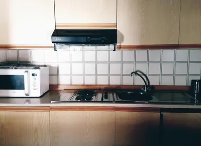 a kitchen with a stove and a microwave at Casa Ciotoli in Falcade