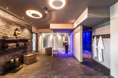 a lobby with a stone wall and a statue on the wall at Mair Am Ort Living Hotel B&B in Parcines