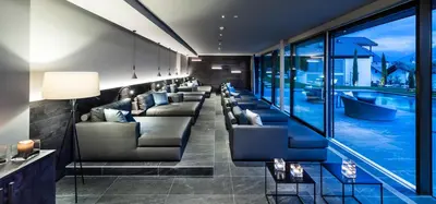 a waiting room with couches and a swimming pool at Mair Am Ort Living Hotel B&B in Parcines