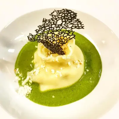 a plate of food with a green sauce and a dessert at Hotel Gardenazza in Badia