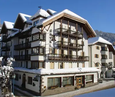 a large white building with snow on it at Hotel Dolomiti Madonna in Ortisei