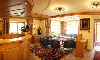 a waiting room with chairs and a bar at Hotel Dolomiti Madonna in Ortisei