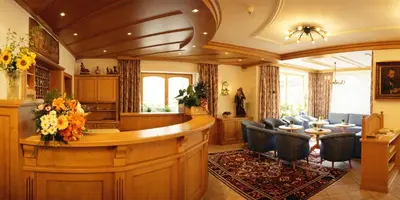 a large room with a bar with chairs in it at Hotel Dolomiti Madonna in Ortisei