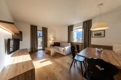 a living room with a table and a couch at hubertus dolomites in Fiè