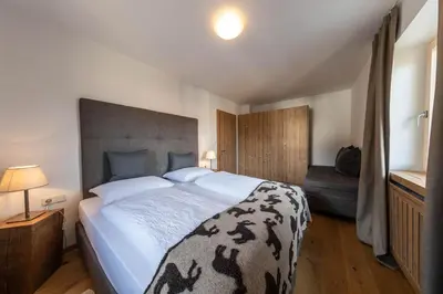 a bedroom with a large bed and a couch at hubertus dolomites in Fiè