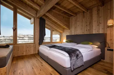 a bedroom with a large bed in a room with windows at hubertus dolomites in Fiè