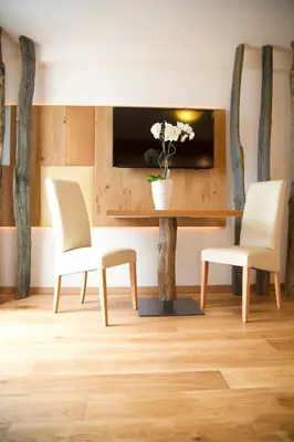 a living room with two white chairs and a table at Panorama in Termeno