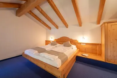 a bedroom with a large wooden bed in a room at Gartenheim Tramin in Termeno