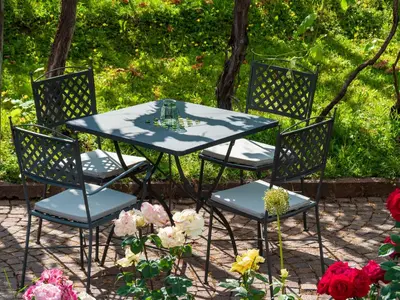 a table and four chairs with a table and flowers at Gartenheim Tramin in Termeno