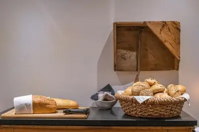 a table with bread and a basket of bread at Gartenheim Tramin in Termeno