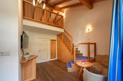 a living room with a staircase and a couch at Gartenheim Tramin in Termeno