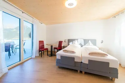 a bedroom with a bed and a table and chairs at Apartments Graf Hartwig in Schenna