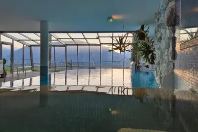 a swimming pool in a house with a blue pool at Apartments Graf Hartwig in Schenna