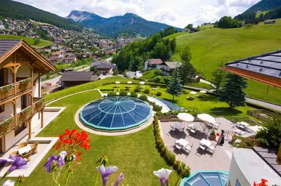 an overhead view of a garden with chairs and tables at Alpin & Vital Hotel La Perla in Ortisei