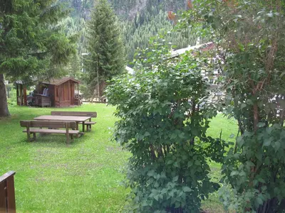 a picnic table and a bench in a park at Appartamenti Col Rodella by AMA Val di Fassa in Campitello di Fassa