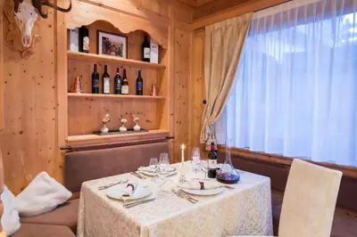 a dining room with a table with wine bottles at Sport Hotel Majarè in Pozza di Fassa
