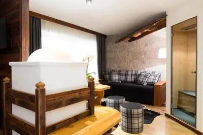 a living room with a couch and a table at Sport Hotel Majarè in Pozza di Fassa