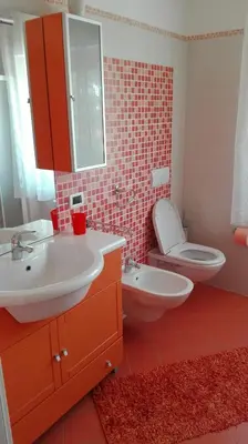 a bathroom with a white sink and a toilet at Casa Novella in Revò