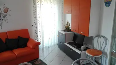 a living room with a red couch and a tv at Casa Novella in Revò