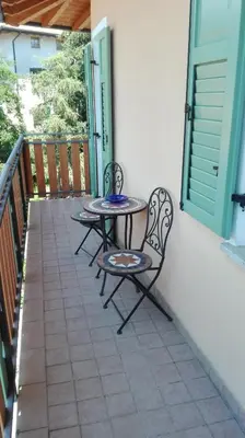 two chairs and a table on a balcony at Casa Novella in Revò