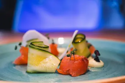 a plate of food with fruit and vegetables on it at Mountain Design Hotel Eden Selva in Selva di Val Gardena