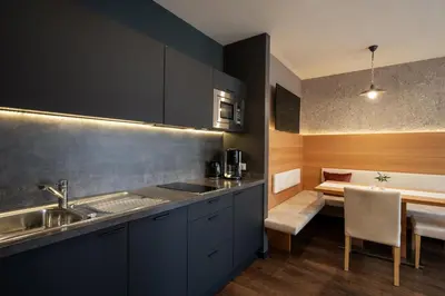 a kitchen with a sink and a dining table at Alagundis Apartment Residence in Lagundo