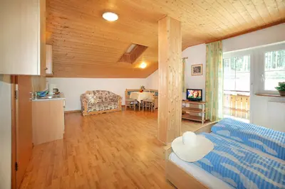 a living room with a blue couch and a kitchen at Residence St Konstantin in Fiè