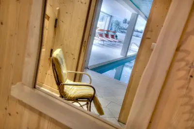 a yellow chair sitting in a room next to a pool at Sporthotel Spoegler in Collalbo