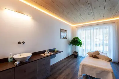 a bathroom with a sink and a large bed at Hotel Teresa in San Vigilio Di Marebbe