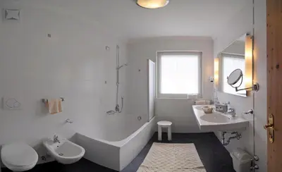 a white bathroom with a tub and a sink and a toilet at Hotel Teresa in San Vigilio Di Marebbe
